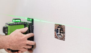 electrician installs sockets apartment checking installed sockets wall apartment with laser level selective focus sockets 300x176 1