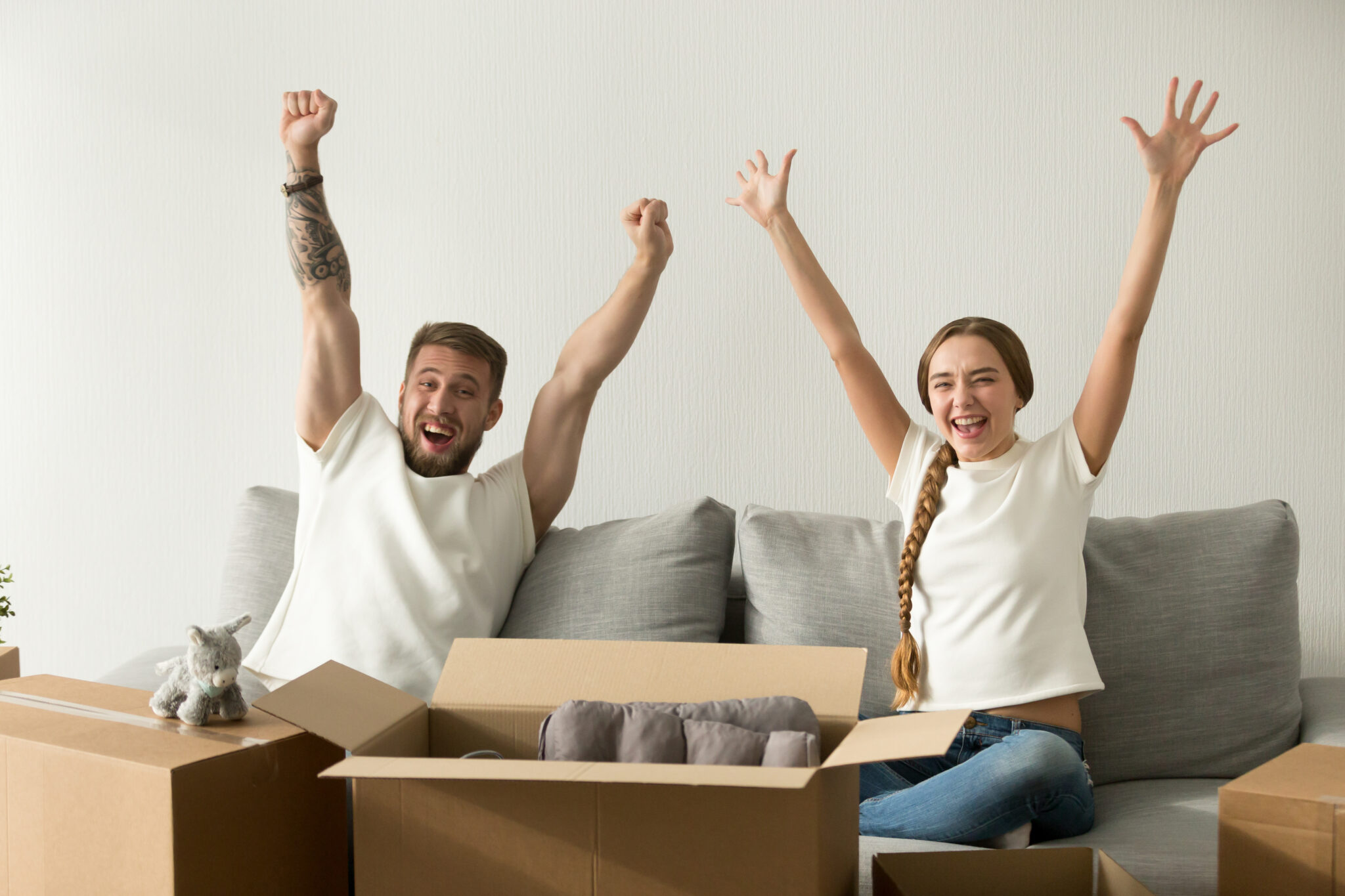 excited couple raising hands happy move new house 2048x1365 1